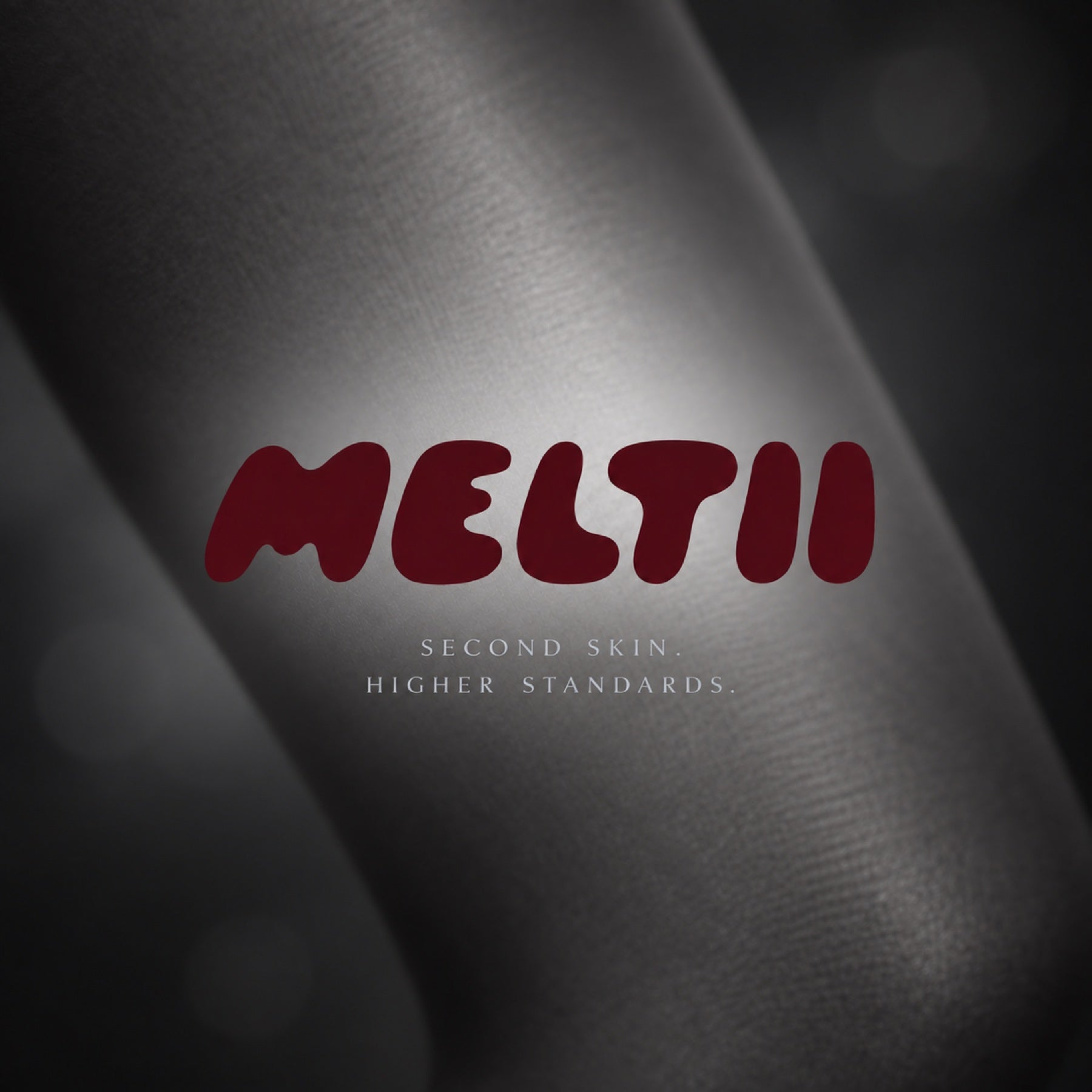 MELTII. Second skin. Higher standards. A cherry wordmark over softly focused gray hosiery.