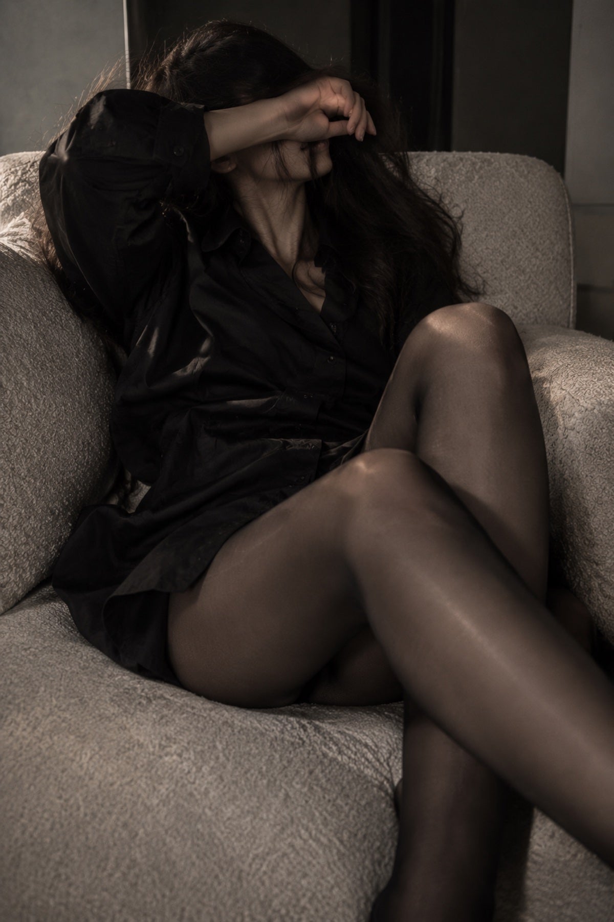A quiet moment in black tailoring and sheer hosiery.